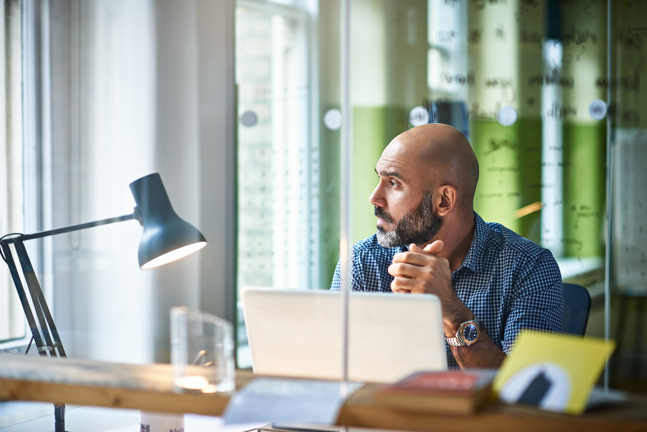 Businessman sitting in front of laptop in modern office.